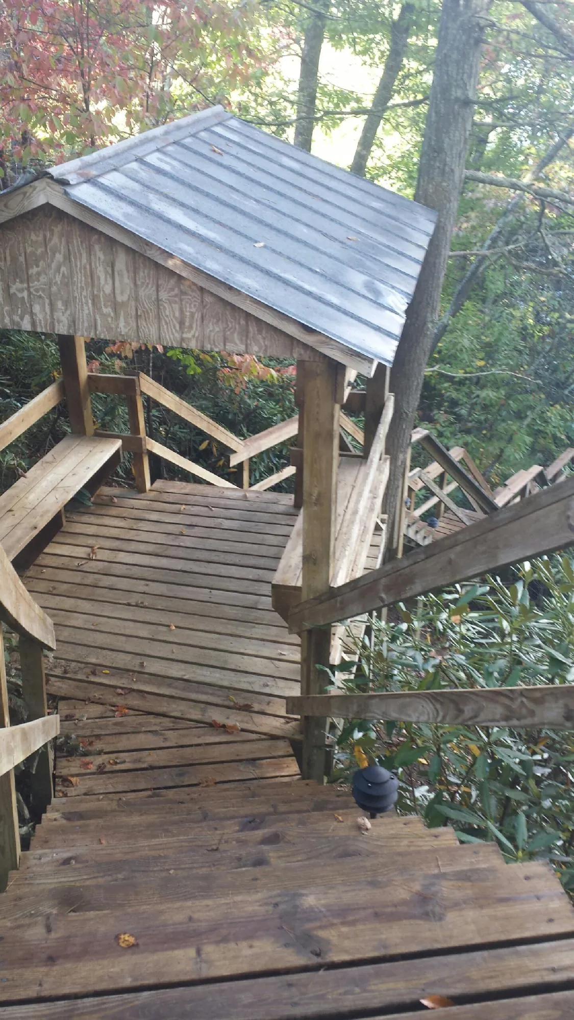 Metal roofed shelter over wooden steps on a wooded walkway — Skylight Repair & Installation work by our crew in Callender